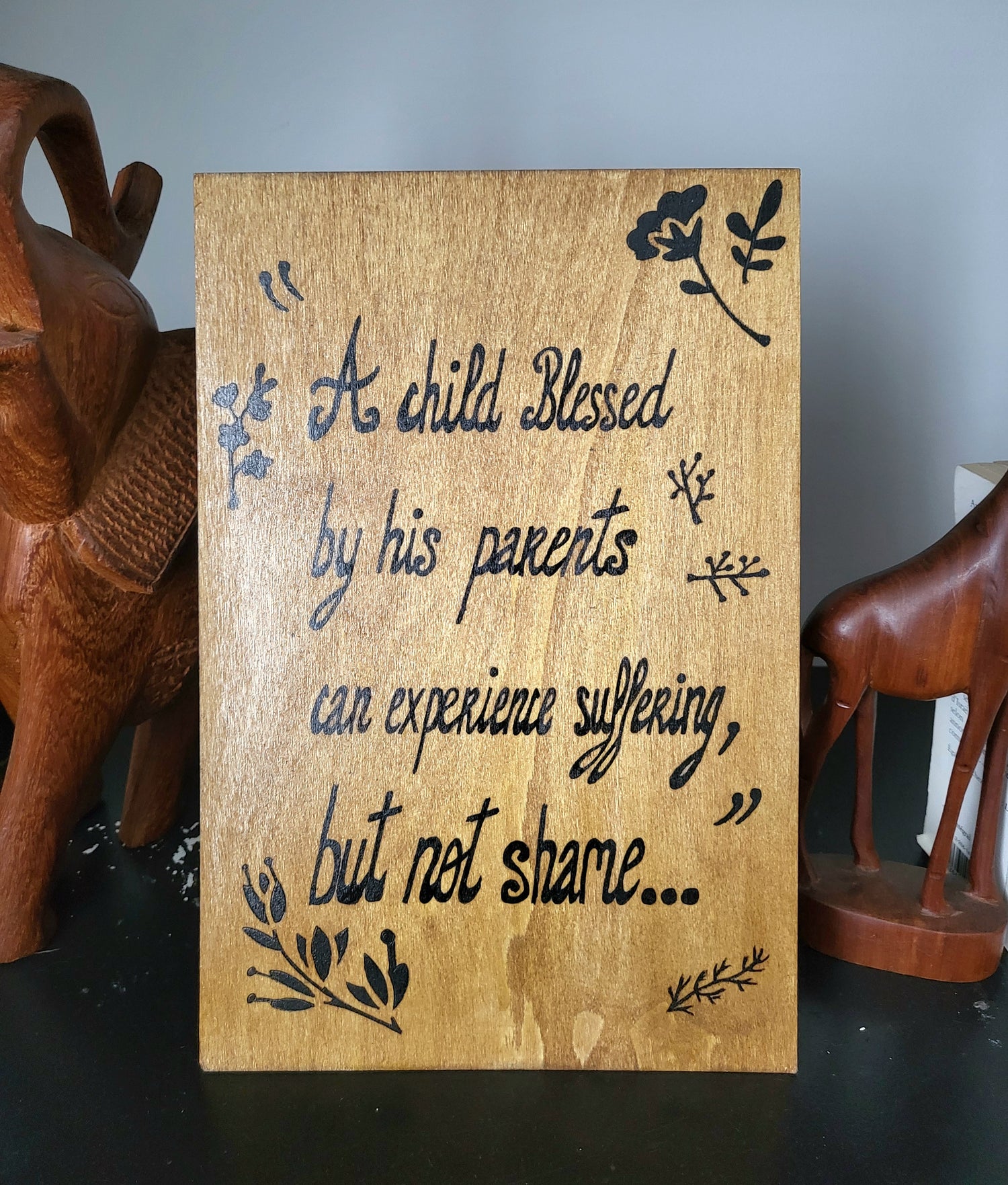 Light brown wood Art wall " A child blessed by his parents can experience suffering but not shame.."